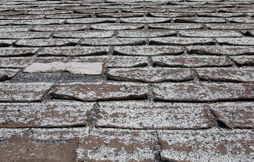 image of Old worn out asphalt shingles on the roof of a residential home.