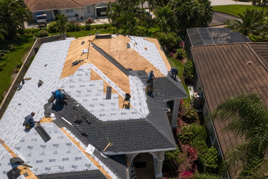 Professional roofing crew installing new shingles and underlayment on a Florida home in the Tampa Bay area