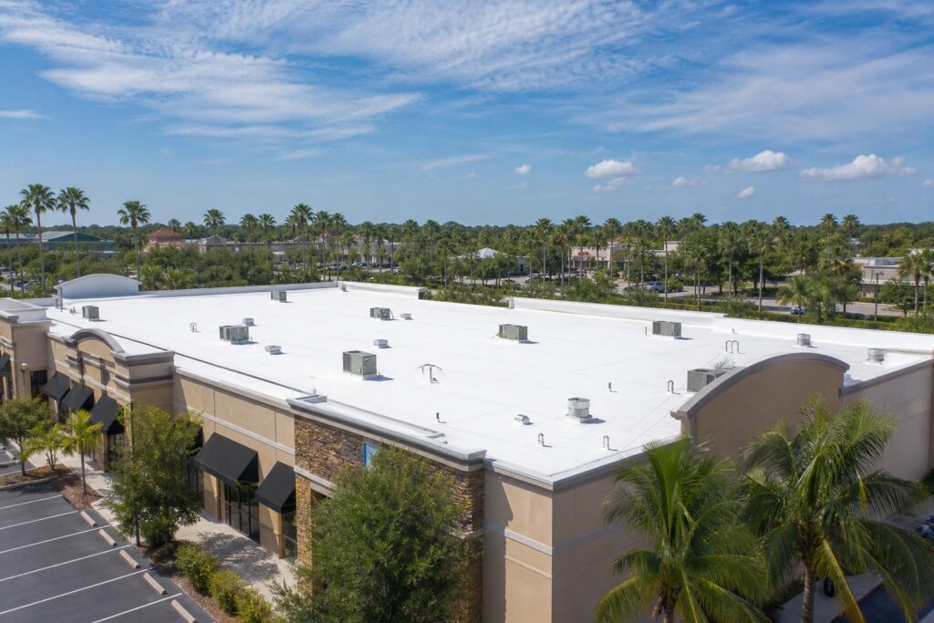 White flat TPO roof on a commercial building in Tampa Bay Florida with palm trees