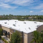 White flat TPO roof on a commercial building in Tampa Bay Florida with palm trees