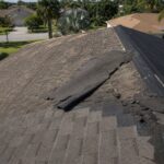Multiple layers of asphalt shingles peeling back on a Florida home roof showing why roof-overs cause problems in Tampa Bay